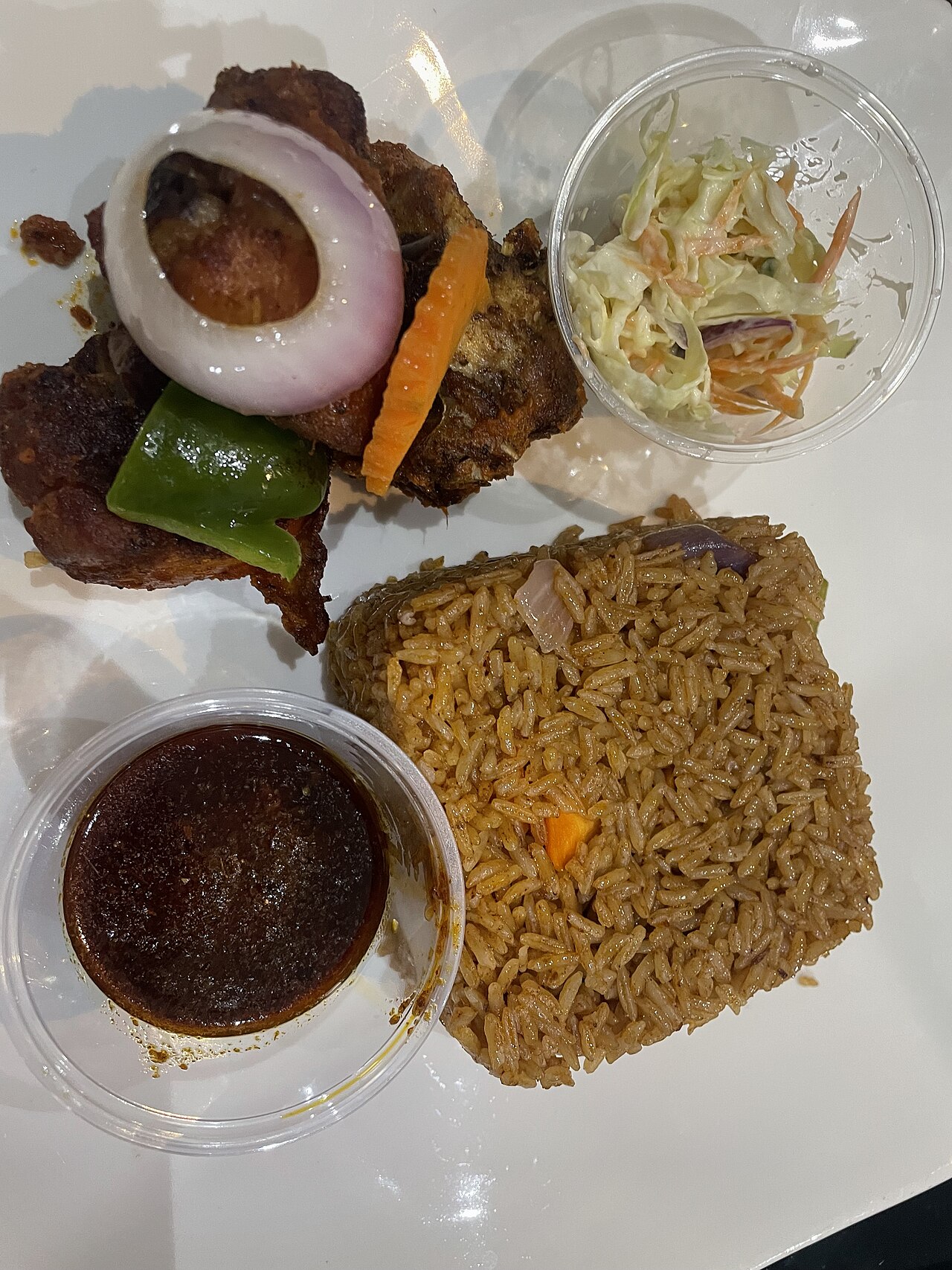Jollof rice with chicken — a typical celebration dish; smaller initial portions and eating slowly help at social events